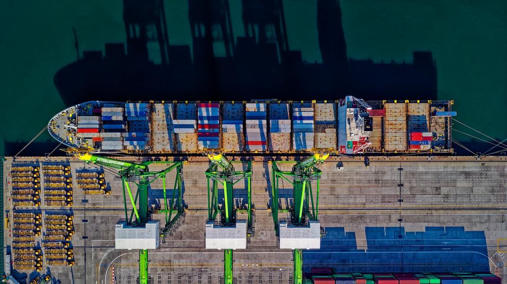 bird’s perspective of a container ship being unloaded